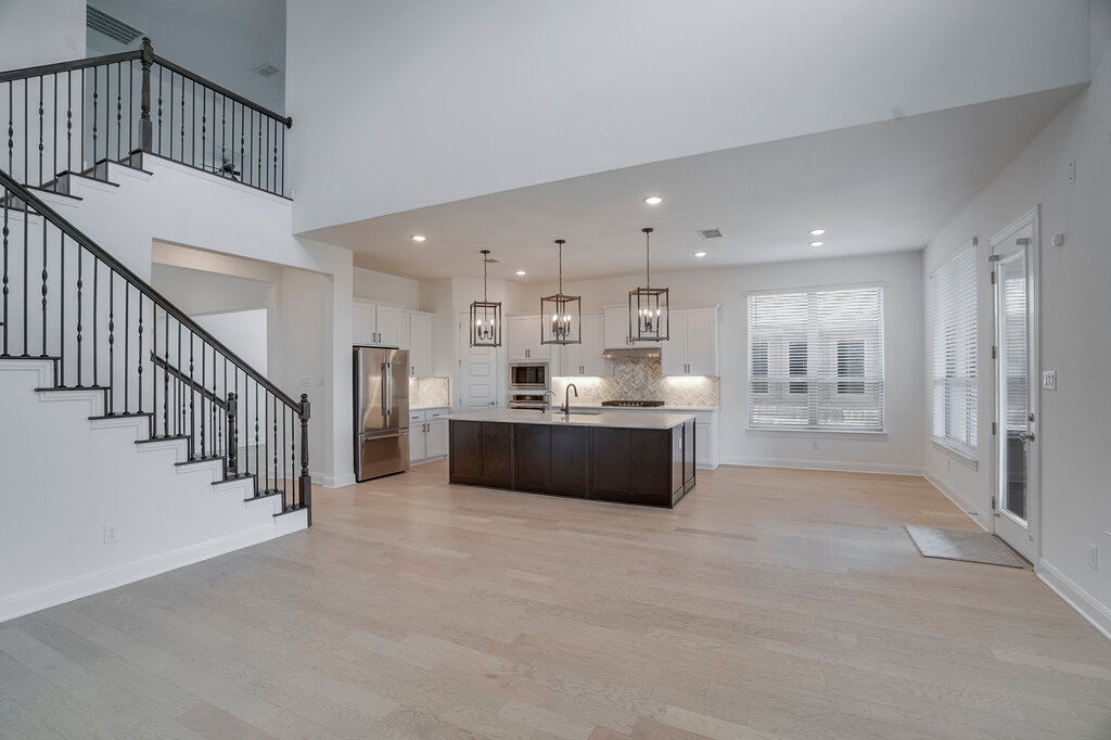 2920 Hadley Way Leander, TX 78641 - Photo 5 of 20 A grand staircase overlooks the open-concept living space with a large kitchen island.