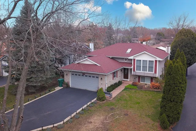a aerial view of a house with a yard and large tree