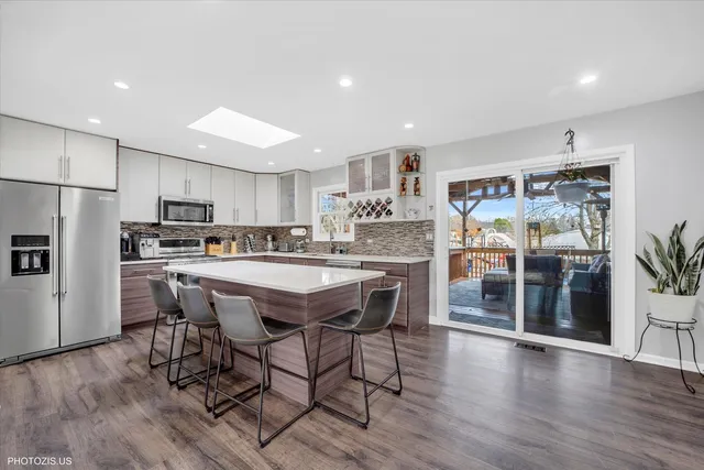 a large kitchen with stainless steel appliances granite countertop a lot of counter space and wooden floors