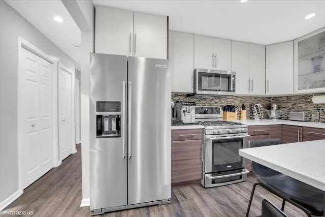 a kitchen with a refrigerator a sink and cabinets