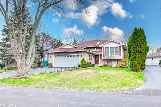 a front view of a house with a garden and yard