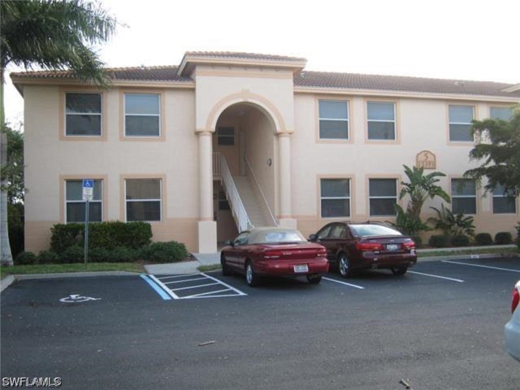 a front view of a house with parking space and a car parked