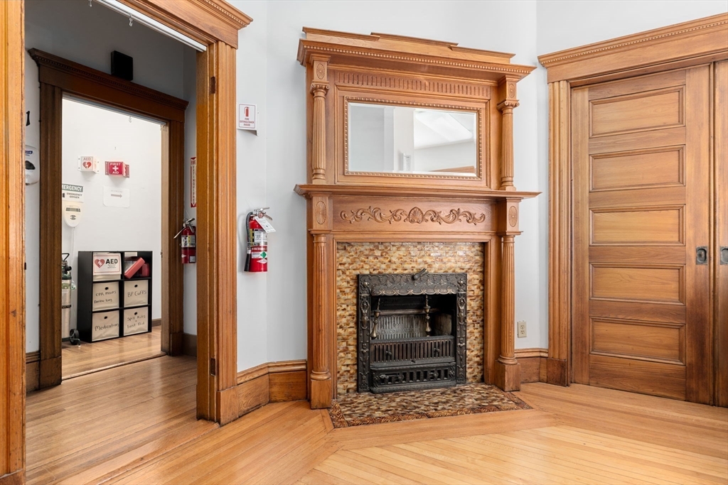 826 Broadway Everett, MA 02149 - Photo 22 of 41 a view of an empty room with wooden floor and a fireplace