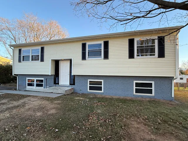 a view of a house with a yard and wooden fence