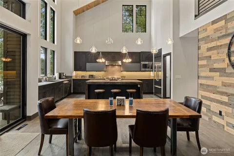 a dining room with a table chairs and a kitchen view