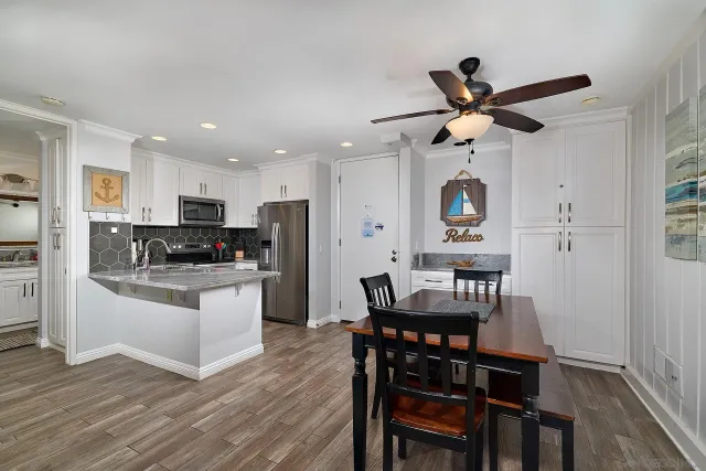 a kitchen with stainless steel appliances kitchen island granite countertop a dining table chairs and granite counter tops