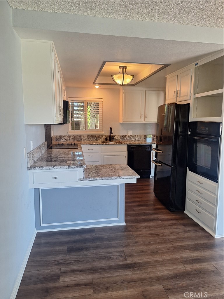 2139-unit A Ronda Granada, Unit A Laguna Woods, CA 92637 - Photo 5 of 8 a view of kitchen with refrigerator microwave and stove with wooden floor