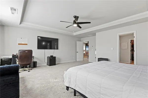 a bedroom with a bed flat screen tv and couches