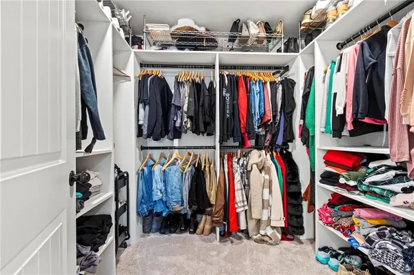 a view of walk in closet with clothes