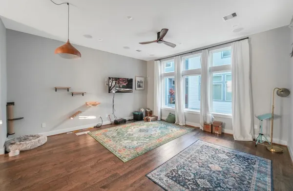 a view of a livingroom with wooden floor and a ceiling fan