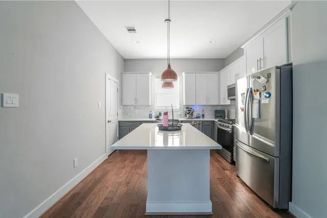 a kitchen with kitchen island a counter top space stainless steel appliances and a window