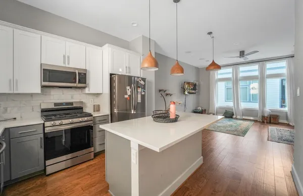 a kitchen with stainless steel appliances kitchen island granite countertop a stove a sink and a refrigerator