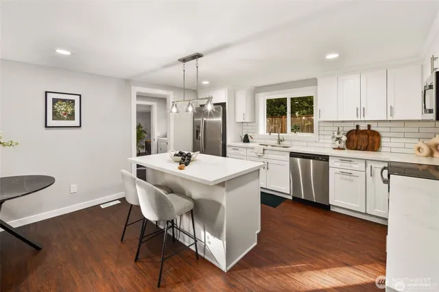 a kitchen with a sink a stove cabinets and wooden floor