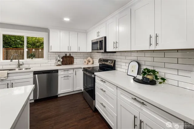 a kitchen with sink a microwave and cabinets
