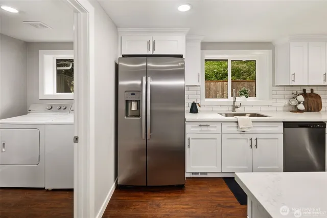 a kitchen with white cabinets and refrigerator