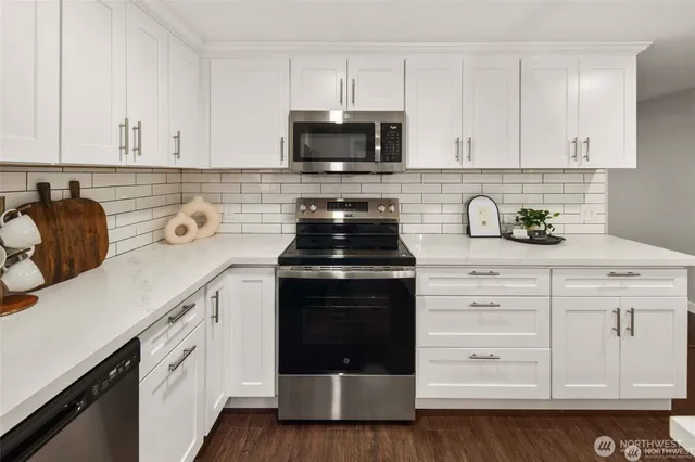 a kitchen with white cabinets and appliances