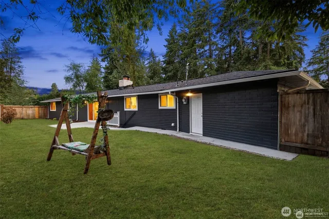 a view of house with backyard and a slide