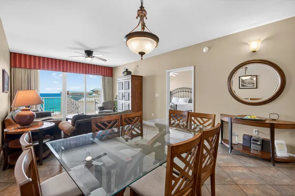 a living room with furniture a large window and a dining table