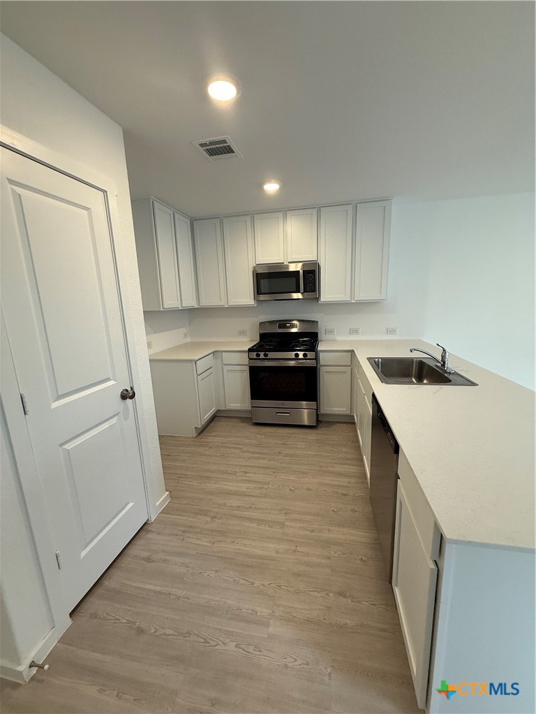 3230 Mound Ridge New Braunfels, TX 78130 - Photo 2 of 15 a kitchen with a sink a stove top oven and refrigerator