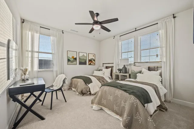 a bedroom with two beds and windows