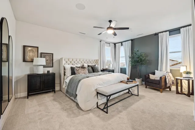 a spacious bedroom with a bed and a chandelier