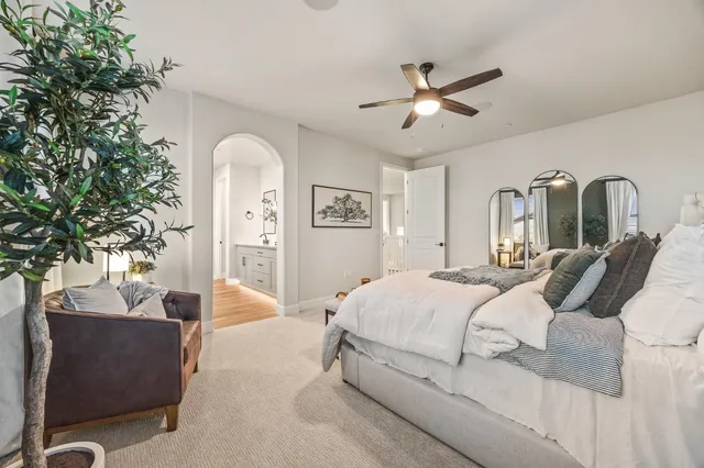 a bedroom with a large bed and a chandelier