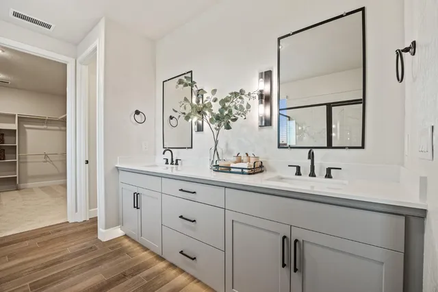 a bathroom with a double vanity sink and mirror