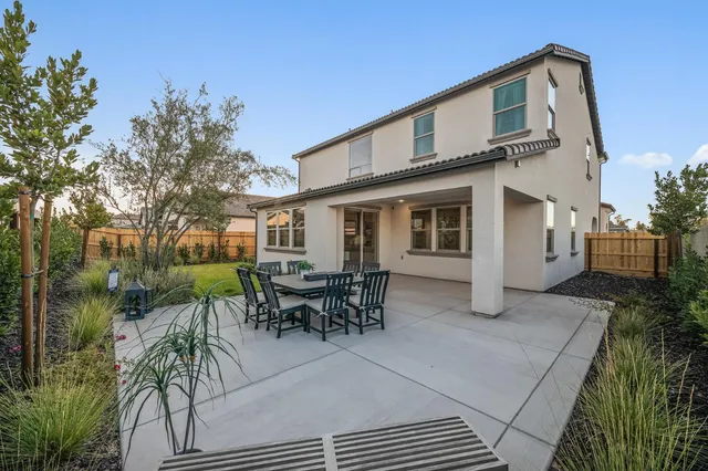 a view of a house with patio and a yard