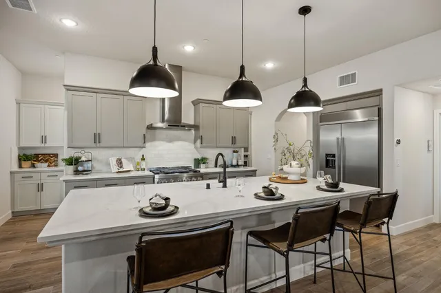 a kitchen with a stove a sink a center island and cabinets