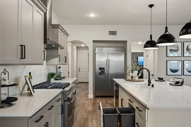 a kitchen with stainless steel appliances a sink a stove and a refrigerator
