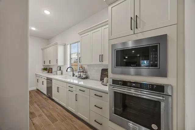 a kitchen with stainless steel appliances white cabinets and a stove