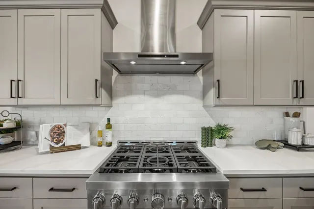 a kitchen with white cabinets and a stove