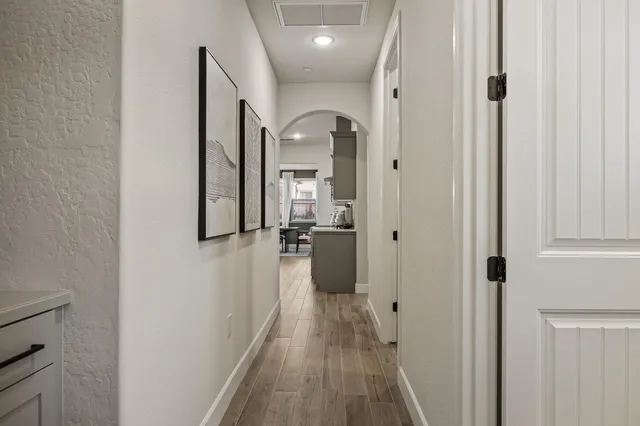 a view of a hallway with a livingroom and a bathroom with sink