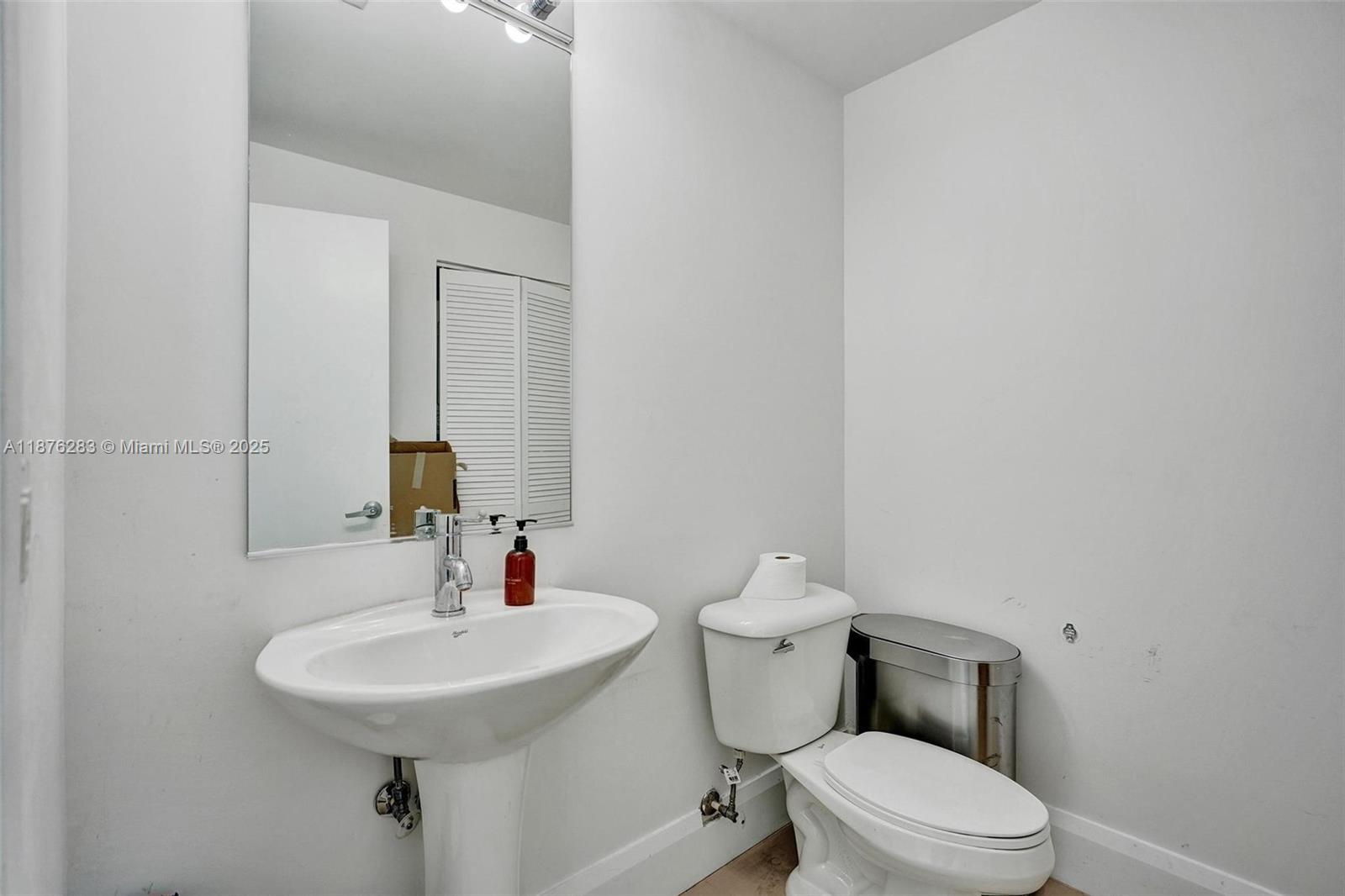 888 Biscayne Boulevard, Unit 5102 Miami, FL 33132 - Photo 11 of 34 a bathroom with a sink toilet and mirror