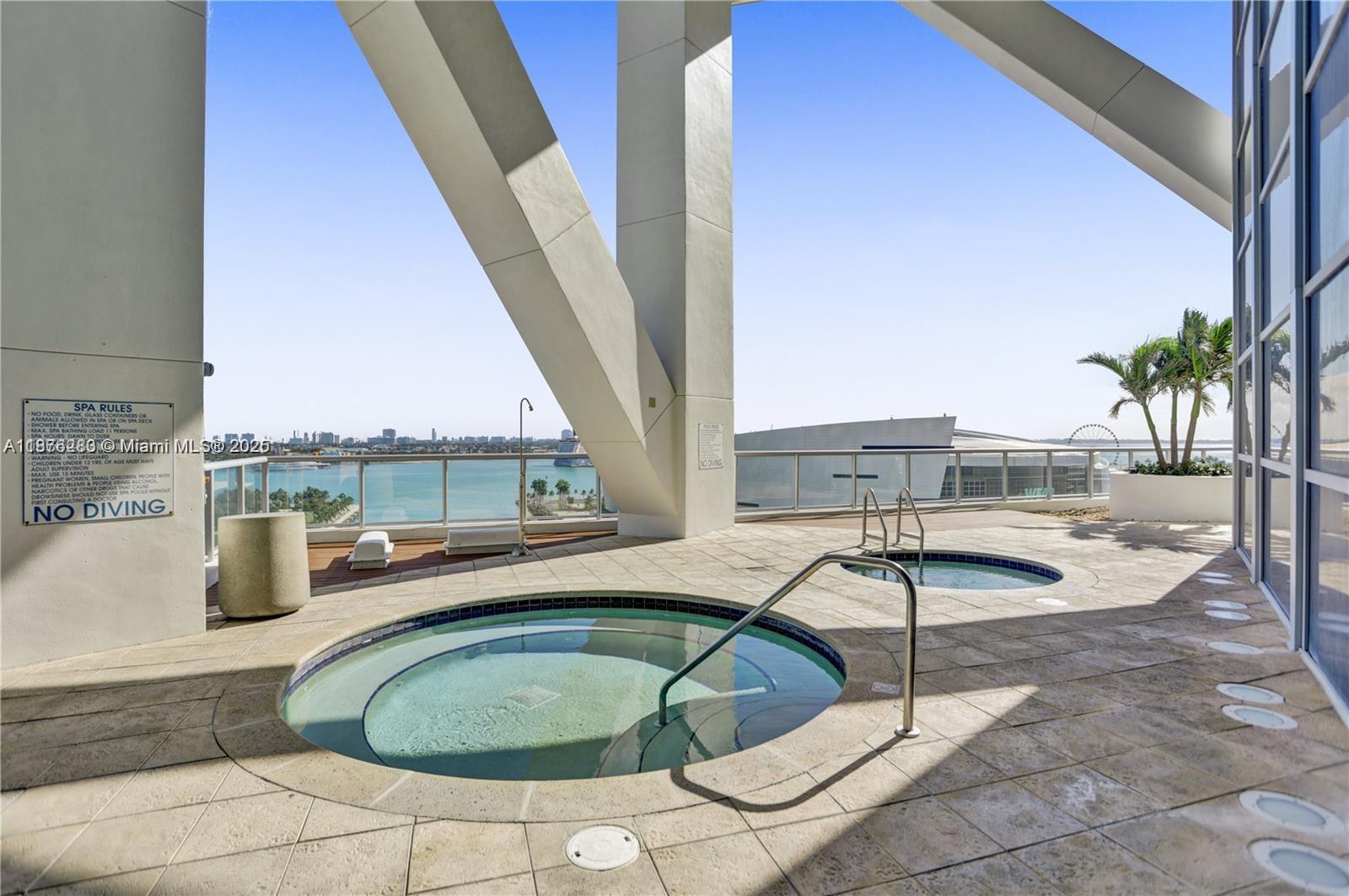 888 Biscayne Boulevard, Unit 5102 Miami, FL 33132 - Photo 26 of 34 a swimming pool with an outdoor seating and house in the background