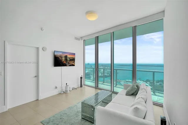 a living room with stainless steel appliances kitchen island granite countertop furniture and a view of kitchen