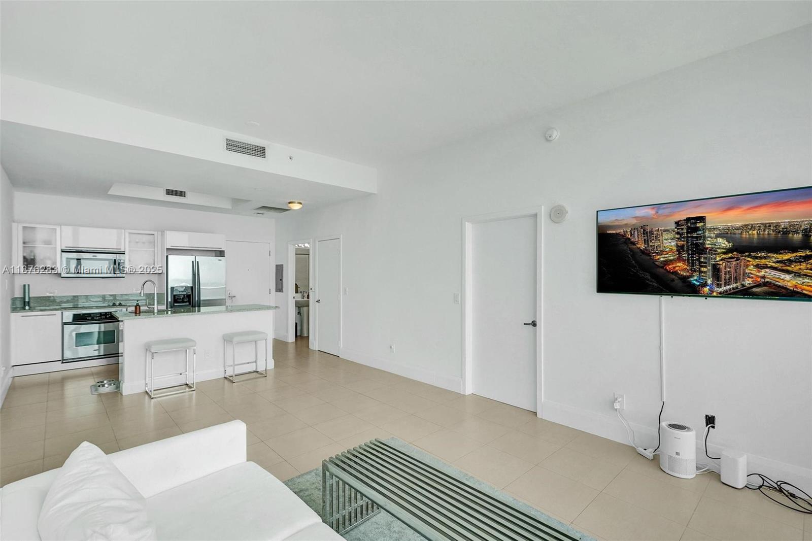 888 Biscayne Boulevard, Unit 5102 Miami, FL 33132 - Photo 5 of 34 a living room with stainless steel appliances kitchen island granite countertop furniture and a view of kitchen