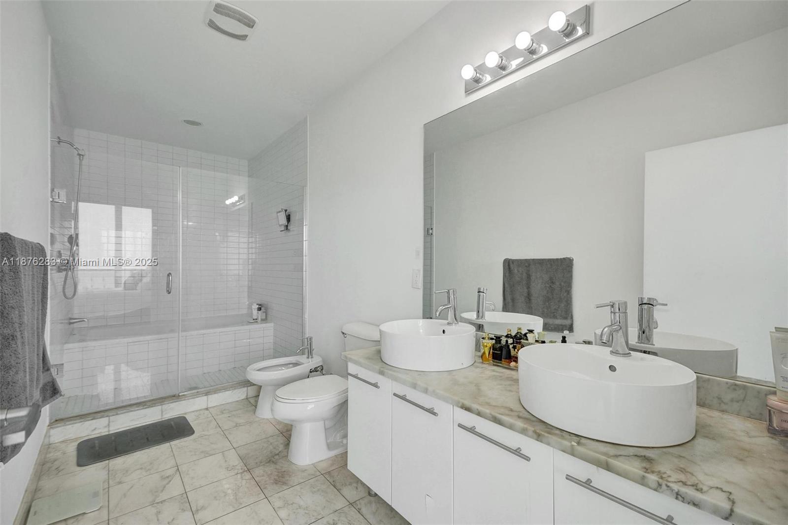 888 Biscayne Boulevard, Unit 5102 Miami, FL 33132 - Photo 10 of 34 a bathroom with a granite countertop sink a toilet a mirror and shower