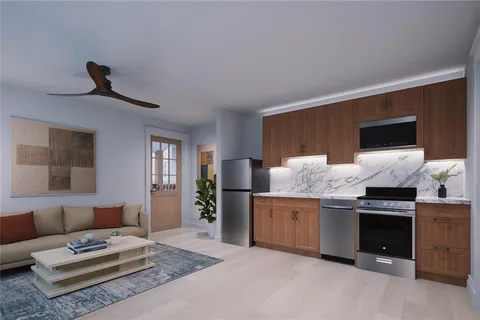 a kitchen view with stainless steel appliances kitchen island a stove a refrigerator and a couch