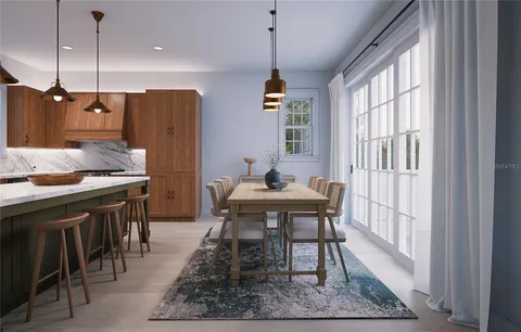 a open kitchen with stainless steel appliances granite countertop a stove a sink dishwasher a dining table and chairs with wooden floor