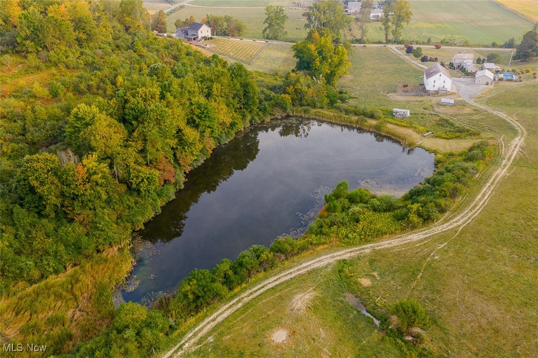1188 Frys Valley Road Southwest New Philadelphia, OH 44663 - Photo 13 of 50 Aerial view of property and surrounding area with rural landscape, a large body of water, and farmland