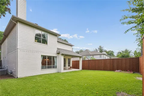 a view of a yard in front of a house with wooden fence