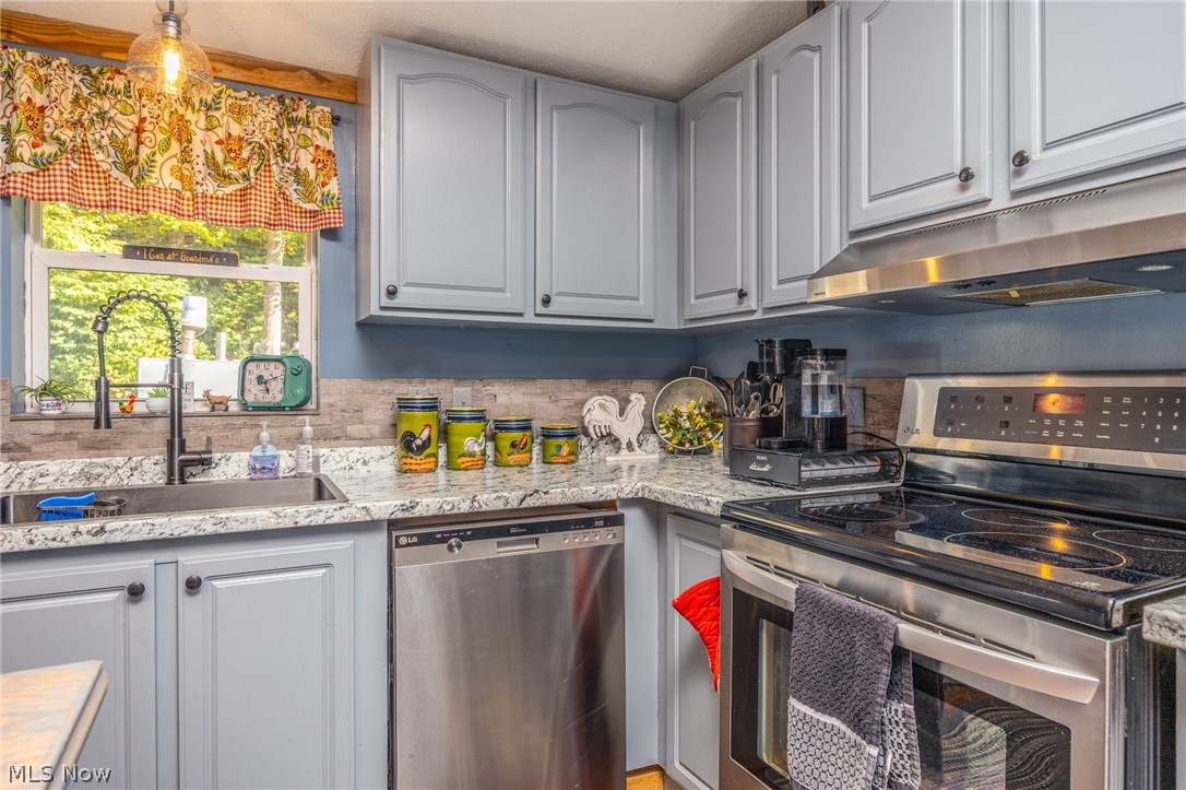 1788 Rosenbush Road Newport, OH 45768 - Photo 10 of 43 Kitchen featuring light gray cabinetry, stainless steel appliances, a white speckled countertop, and a tiled backsplash