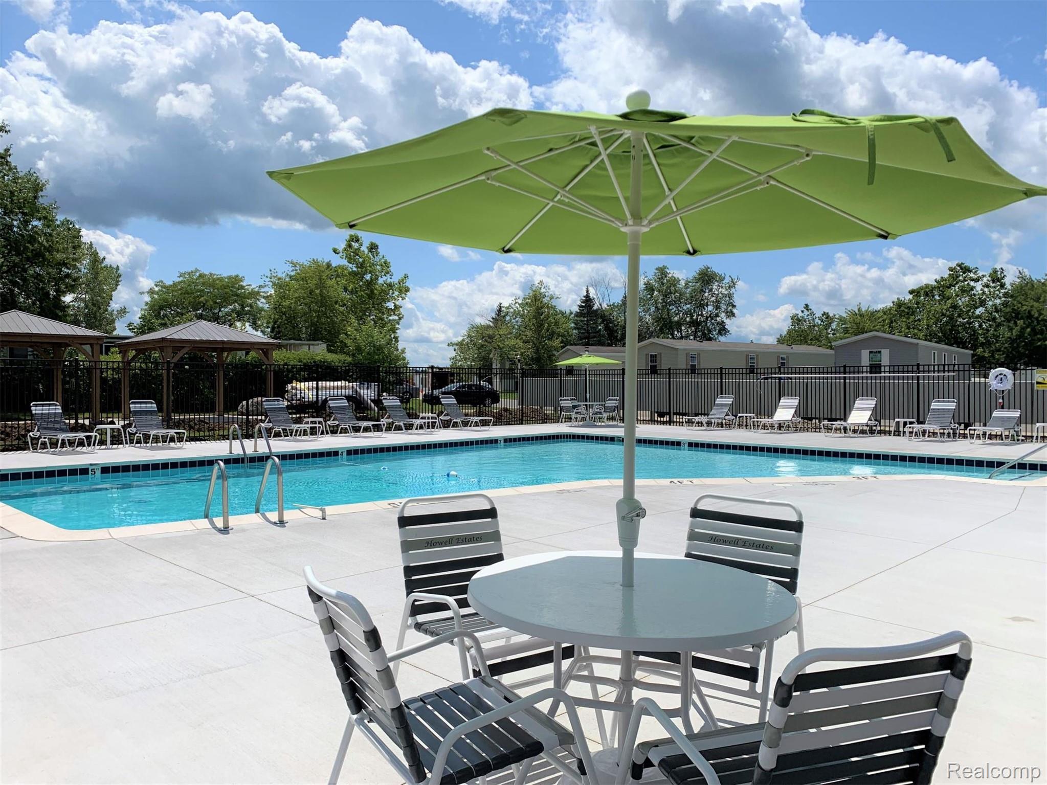 92 Normandy Drive Howell, MI 48843 - Photo 23 of 24 Outdoor swimming pool with integrated steps, surrounded by a concrete deck