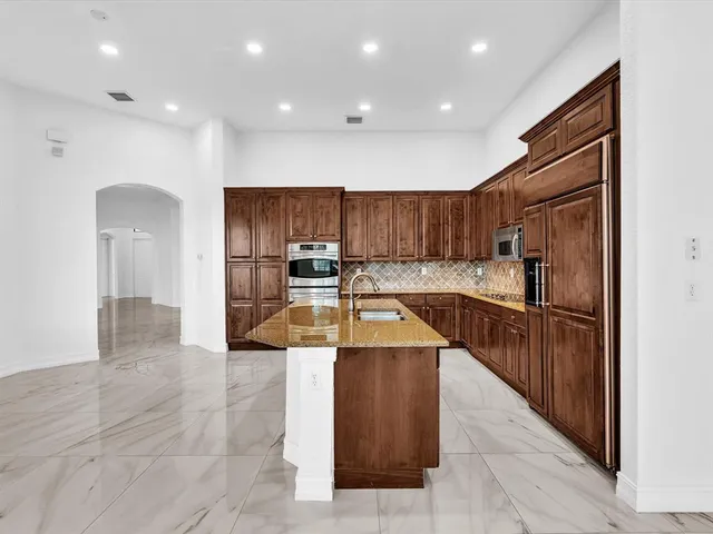 a view of a kitchen with a refrigerator and a floor to ceiling window