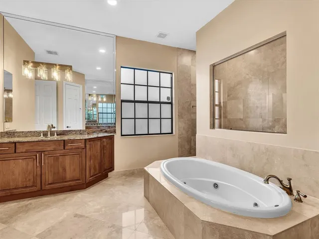 a bathroom with a granite countertop sink a mirror and a shower