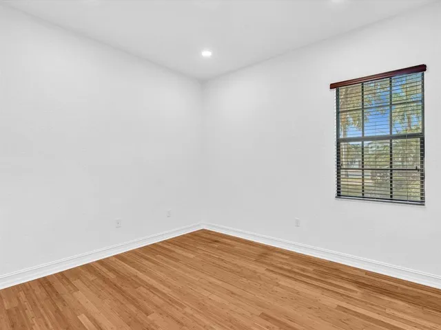 an empty room with wooden floor and closet