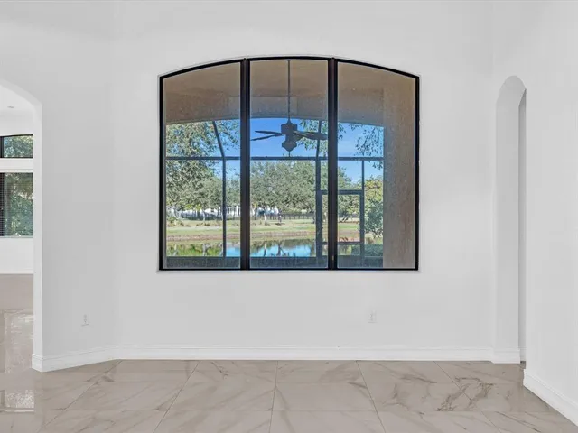a view of a hallway with wooden floor and a bathroom