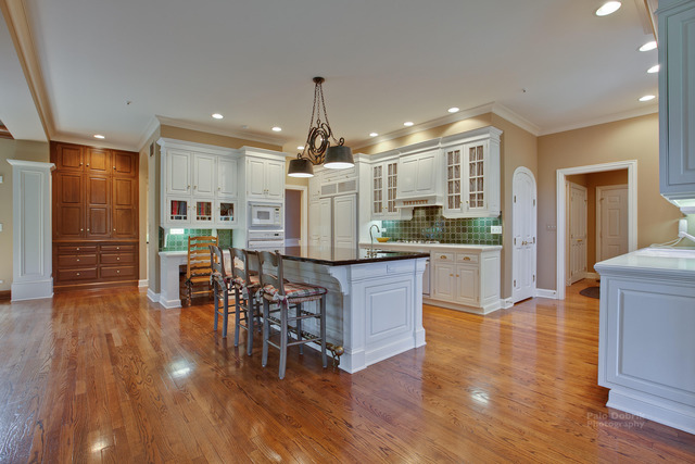 1390 Gettysburg Road Long Grove, IL 60047 - Photo 10 of 25 a kitchen with stainless steel appliances kitchen island wooden floors stove and white cabinets