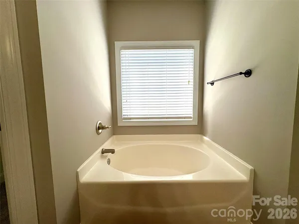 a white bath tub sitting in a bathroom next to a window